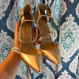Gold heels with a buckle around the ankle